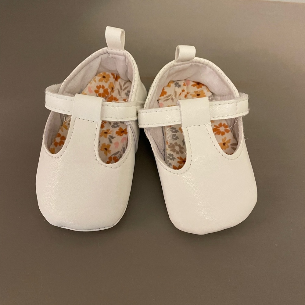 White baby shoe with floral print inside. Size 2